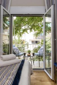 a bedroom with a bed and a balcony with a table at Kookaki Athens City Stay by Raise in Athens