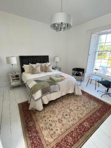 a bedroom with a large bed and a rug at Bank House in Inistioge
