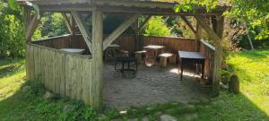 a wooden gazebo with tables and chairs in it at Niedźwiedziówka in Mrągowo