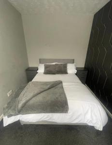 a bedroom with a large bed with a blanket on it at Cosy, modern Apartment in Darlaston