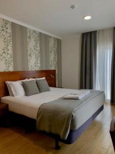 a bedroom with a large bed in a room at Hotel Vila Verde in Castro Verde