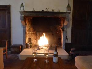 a fireplace with two wine glasses and a bottle of wine at Belle Maison en Bourgogne - Auxois - Morvan in Flée +45 photos