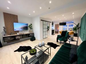 ein Wohnzimmer mit einem Sofa und einem Flachbild-TV in der Unterkunft Ferienwohnung Domizil am Delft II Emden in Emden