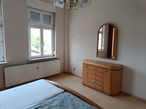 una camera da letto con cassettiera e specchio di FeWo Wüste Worth a Stendal