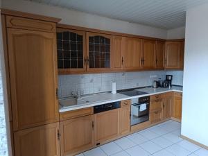 a kitchen with wooden cabinets and a sink at FeWo Wüste Worth in Stendal