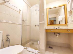 a bathroom with a shower and a toilet and a mirror at Suíte 455 Wish Resort Gramado in Gramado