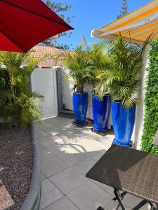 a patio with blue potted plants and a table with an umbrella at Playa Del Ingles in Playa del Ingles