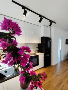 uma cozinha com flores cor-de-rosa num vaso num balcão em Holiday home Maslina em Orebić