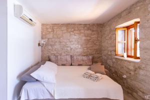 a small bedroom with a white bed and a window at Apartman Điran in Biograd na Moru
