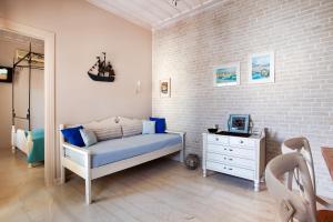 a bedroom with a bed and a dresser and a brick wall at Alkionides Seaside Hotel in Platanias