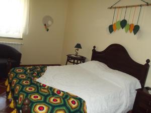 sypialnia z białym łóżkiem i kolorowym kocem w obiekcie Quinta do Pina w mieście Guarda