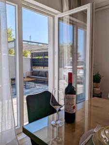 Holiday home Maslina في أوربيك: زجاجة من النبيذ موضوعة على طاولة مع كأس من النبيذ