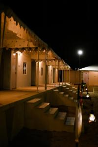 a building with a row of benches at night at Shrinath Desert Camp in Jaisalmer