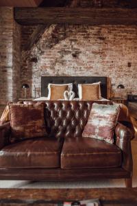 a brown leather couch in a room with a bed at Broederenklooster in Zutphen