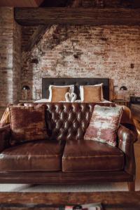 ズトフェンにあるBroederenkloosterのベッド付きの客室で、茶色の革張りのソファが備わります。