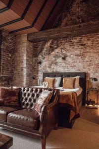 a bedroom with a bed and a leather couch at Broederenklooster in Zutphen