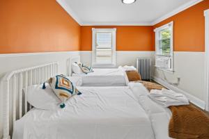 twee bedden in een kamer met oranje muren bij Modern and Tropical Vibe 3BR Apt near AC Beach in Atlantic City