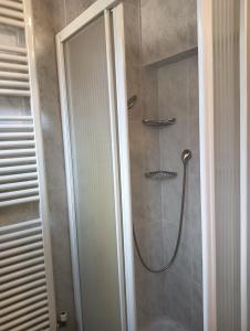 La salle de bains est pourvue d'une douche avec une porte en verre. dans l'établissement La casa di Marilyn in Fiera, à Bologne