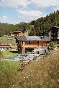 a large house with a pool in front of it at Luxury Spa Chalet Lum d'Or in Selva di Val Gardena