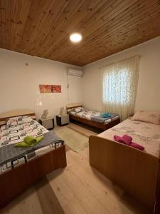 1 dormitorio con 2 camas y techo de madera en Apartman Vesna, en Virpazar