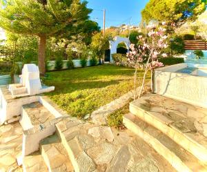 um jardim com um banco e árvores e relva em Villa Naya by the Beach em Anavissos