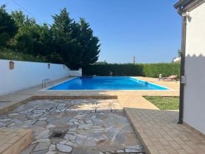 a swimming pool in a yard with a stone patio at SeeConero home in Ancona