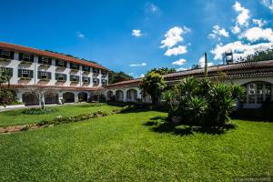 a courtyard of a building with a grass yard at Hotel Bucsky in Nova Friburgo