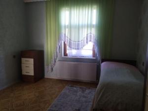 een slaapkamer met een bed en een raam met gordijnen bij Villa in Nakhchivan city, Azerbaijan in Naxçıvan