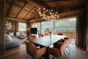 ein Esszimmer mit einem Tisch, Stühlen und einem Sofa in der Unterkunft Luxury Spa Chalet Lum d'Or in Wolkenstein in Gröden