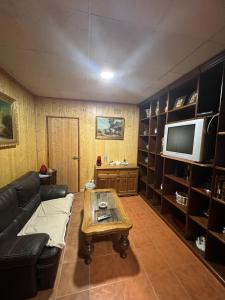 a living room with a couch and a table and a tv at Alojamiento cerro d la salina in Ronda