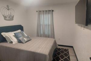 a small bedroom with a bed with a window at Bungalow overlooking Lake Dora! in Tavares