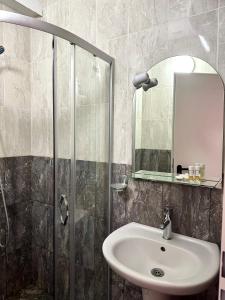 a bathroom with a sink and a shower with a mirror at Eternity - Private Studios in Primorsko