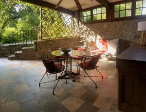 un patio con mesa y sillas en La Frigoule, un gîte au cœur du parc des Cévennes, en Générargues