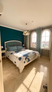a bedroom with a large bed with blue walls and windows at Selena Luxury Monte Carrera in La Playa de Arguineguín