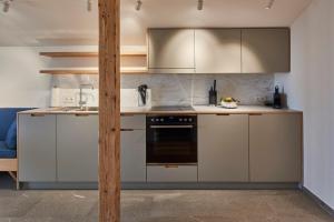 a kitchen with white cabinets and a black oven at AHORN7 in Reit im Winkl