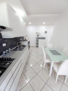 uma cozinha com armários brancos e uma mesa com cadeiras em BELLAVISTA House em San Salvo