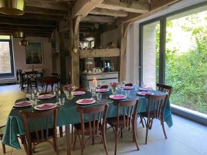 a dining room with a table and chairs and a kitchen at Moulin de la Rouchotte in Frétigney-et-Velloreille