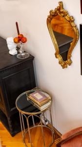 un espejo en una pared junto a una mesa con un taburete en Maxim's place en Timisoara