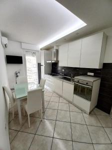 a kitchen with a table and a kitchen with white cabinets at BELLAVISTA House in San Salvo
