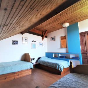 a bedroom with two beds and a wooden ceiling at Surfworx Lodge in Soustons