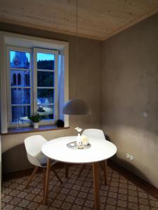 een kamer met een tafel, 2 stoelen en een raam bij Vila Braun in Horní Maršov