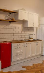 a kitchen with white cabinets and a red refrigerator at Maxim's place in Timişoara