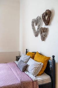 uma cama com almofadas e um coração pendurado numa parede em Maxim's place em Timisoara