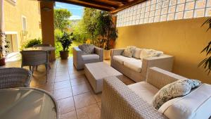 un patio con sofás, sillas y una mesa. en Hotel Il Girasole, en Villasimius