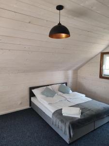 una camera da letto con un grande letto in mansarda di Domek nad stawem z banią a Brodnica