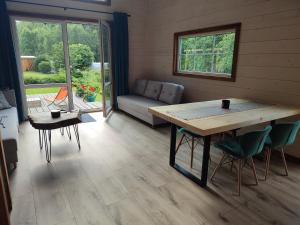 sala de estar con mesa de madera y sofá en Domek nad stawem z banią, en Brodnica