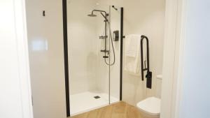 a bathroom with a shower with a glass door at Hostal León in Torreorgaz
