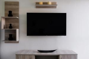 una TV a schermo piatto appesa a un muro di Joseph Seaside Apartment 2 a Heraklion