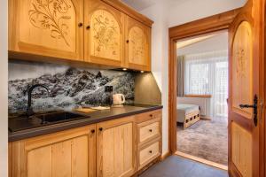 Una cocina con gabinetes de madera y un fregadero. en Modrzewiowa Apartamenty, en Poronin 38 fotos más