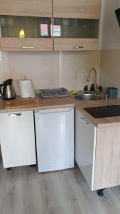 a kitchen with white cabinets and a sink at Apartament Olsztyn Centrum in Olsztyn